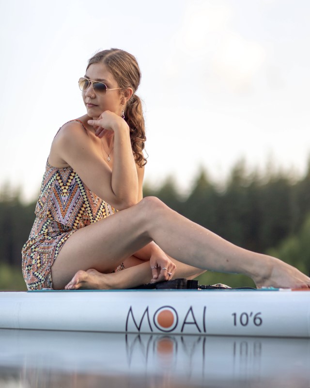Dame zittend op MOAI 10'6 SUP board