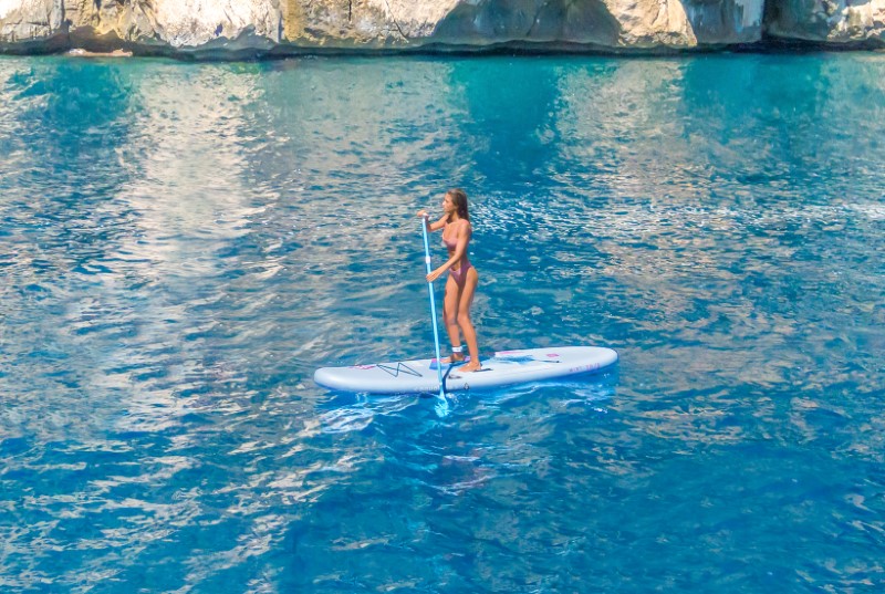 Dame staand op Aquatone Mist 10'4 all-round compact SUP set