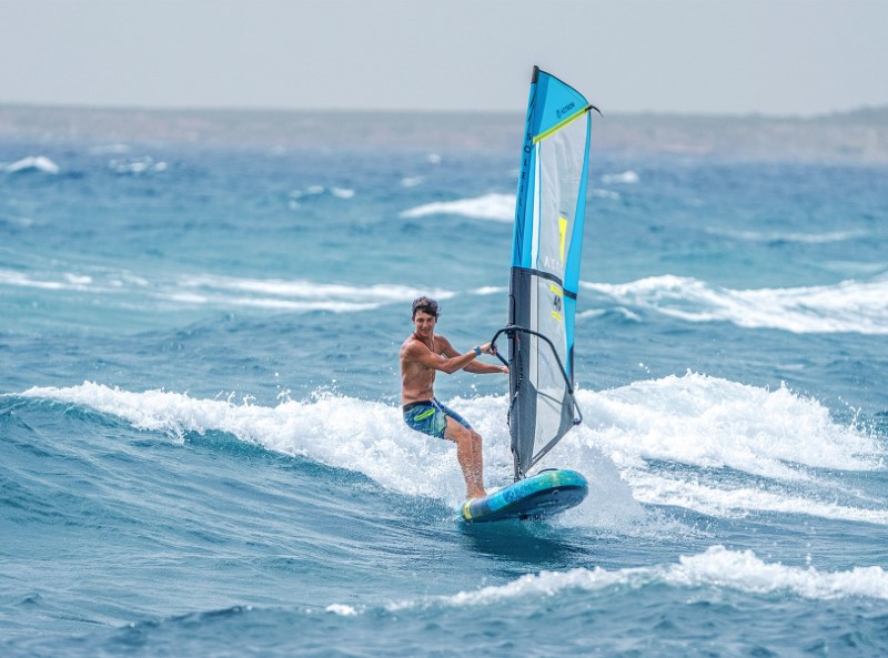 Man surfend met Aztron Soleil 11' Wind SUP Board op zee
